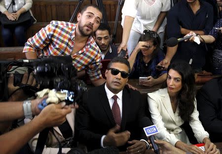 Al Jazeera television journalists Mohamed Fahmy, C, and Baher Mohamed, L, talk to the media with lawyer Amal Clooney (R) before hearing the verdict at a court in Cairo, Egypt, August 29, 2015. REUTERS/Asmaa Waguih