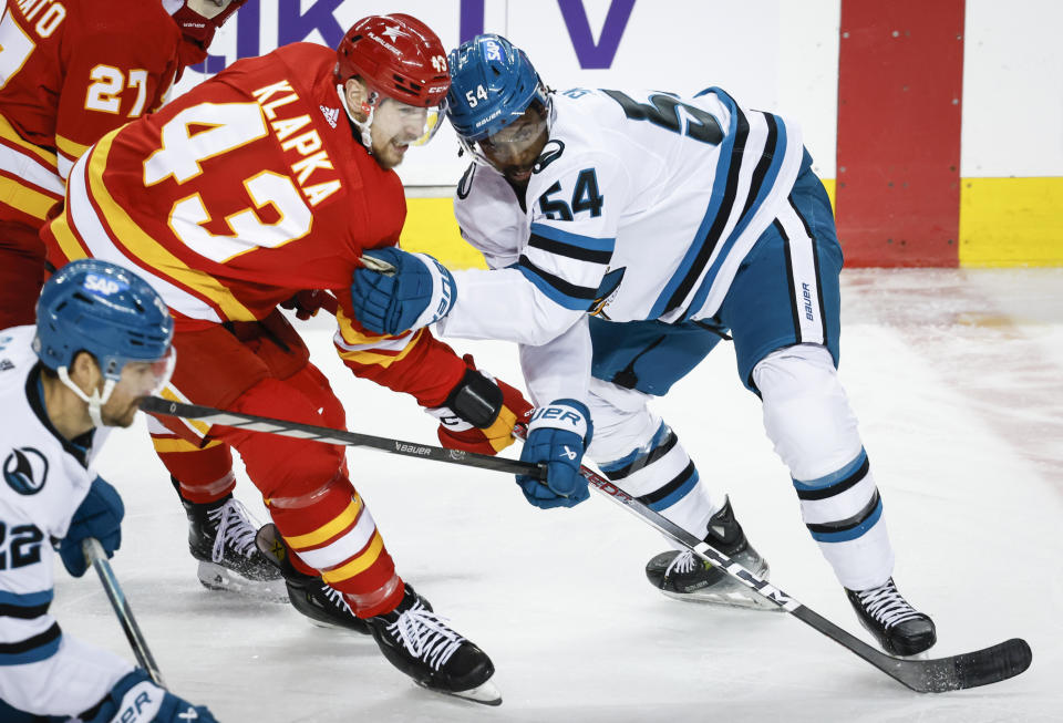 San Jose Sharks forward Givani Smith (54) and Calgary Flames forward Adam Klapka (43) jostle for position during the third period of an NHL hockey game Thursday, April 18, 2024, in Calgary, Alberta. (Jeff McIntosh/The Canadian Press via AP)