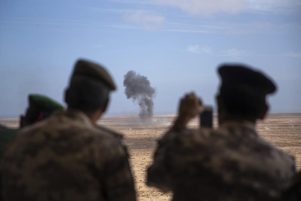 Observers use their phones to record an explosion during a large scale drill as they attend the African Lion military exercise, in Tantan, south of Agadir, Morocco, Friday, June 18, 2021. The U.S.-led African Lion war games, which lasted nearly two weeks, stretched across Morocco, a key U.S, ally, with smaller exercises held in Tunisia and in Senegal, whose troops ultimately moved to Morocco. (AP Photo/Mosa'ab Elshamy)