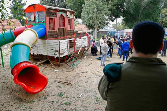 People inspect damage at a kindergarten in the southern Israeli city of Sderot, near the border with the northern Gaza Strip, on February 24, 2020, following a rocket barrage from Gaza (Photo by JACK GUEZ / AFP)