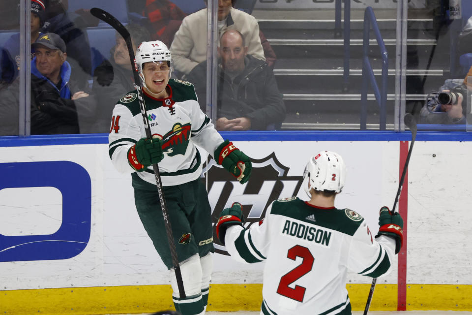 Minnesota Wild center Joel Eriksson Ek (14) celebrates after his goal with defenseman Calen Addison (2) during the third period of an NHL hockey game against the Buffalo Sabres, Saturday, Jan. 7, 2023, in Buffalo, N.Y. (AP Photo/Jeffrey T. Barnes)