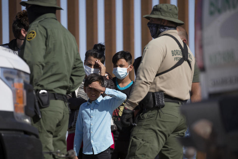 Young migrants from Colombia wait to be processed after turning themselves over to authorities at the United States and Mexico border May 12, 2021 in Yuma, Arizona.  / Credit: RINGO CHIU/AFP via Getty Images