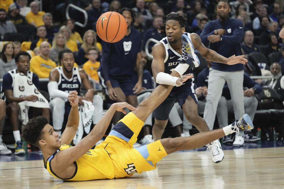 Marquette's Oso Ighodaro loses the ball in front of Butler's Myles Tate during the first half of an NCAA college basketball game Saturday, Feb. 4, 2023, in Milwaukee. (AP Photo/Morry Gash)
