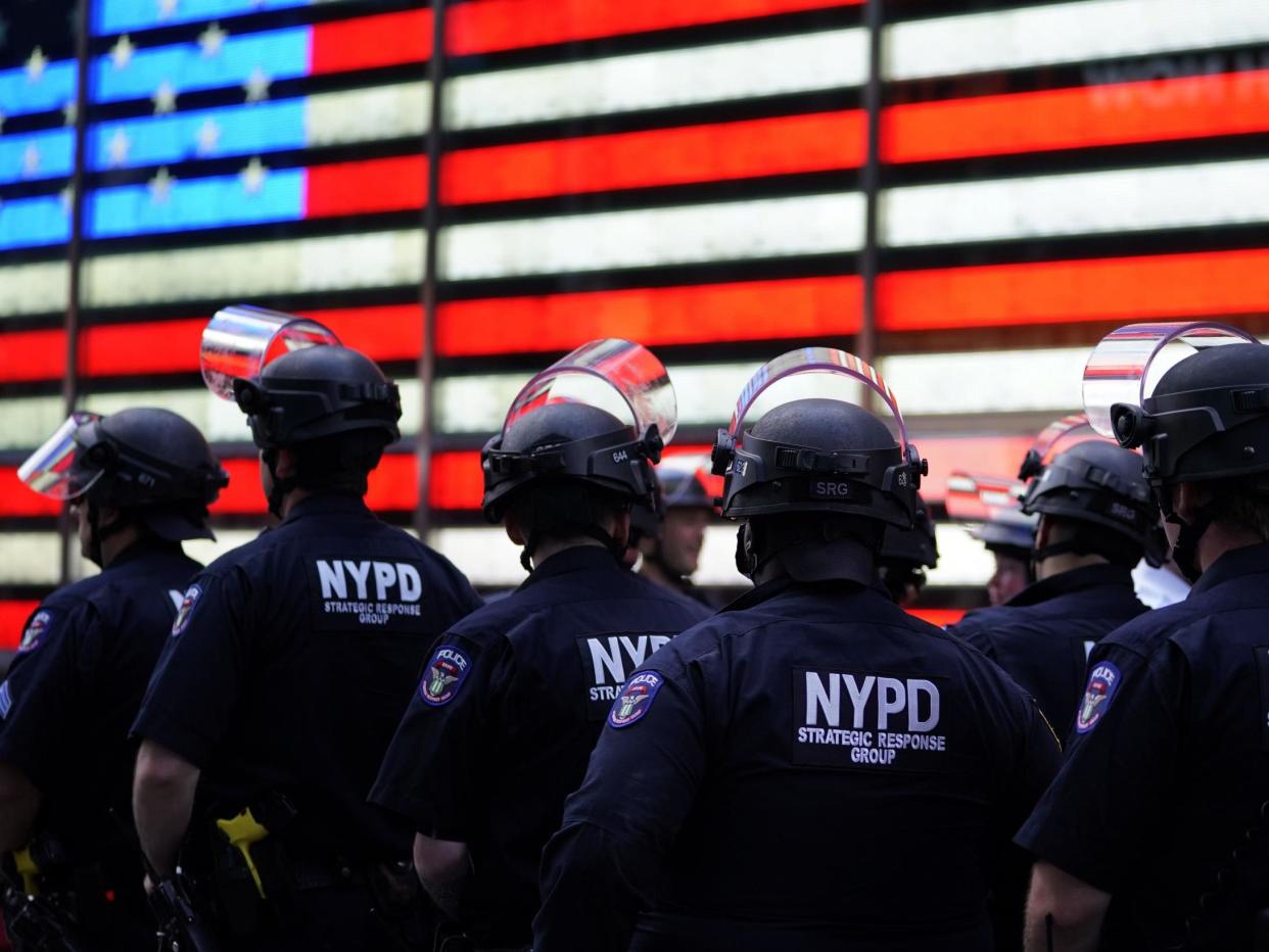 NYPD police officers watch demonstrators in Times Square on 1 June, 2020, during a Black Lives Matter protest: (AFP)