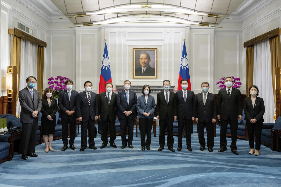 In this photo released by the Taiwan Presidential Office, Taiwan's President Tsai Ing-wen, center, and Taiwanese officials pose for photos with a Japanese delegation led by lawmaker and former Defense Minister Shigeru Ishiba, center left, at the Presidential office in Taipei, Taiwan on Thursday, July 28, 2022. A group of Japanese lawmakers including two former defense ministers met with Taiwan's president on Thursday in a rare high-level visit to discuss regional security. (Taiwan Presidential Office via AP)