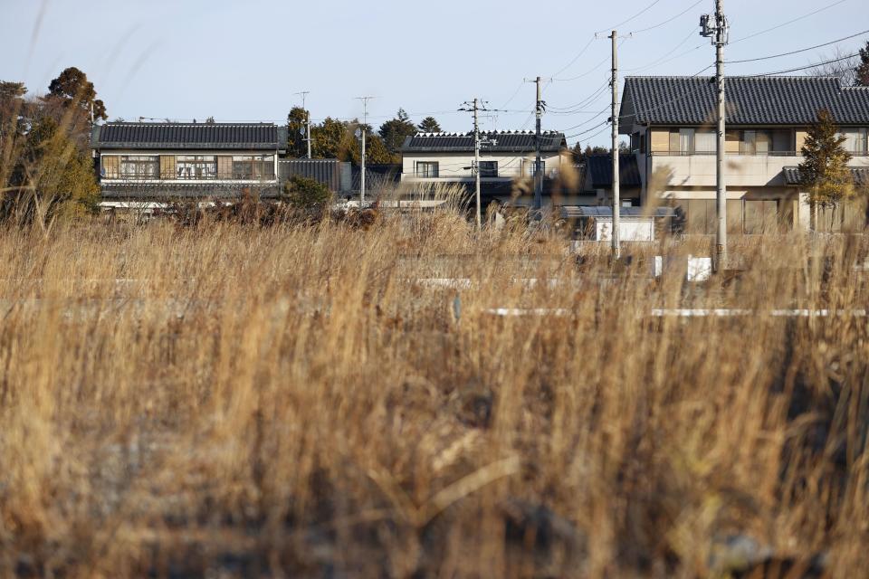 Part of Futaba town of Fukushima prefecture, Japan, looks over weeds Thursday, Jan. 20, 2022. Several former residents of Futaba, the only remaining uninhabited town in Japan still recovering from effects of radiation from nuclear plant meltdowns in 2011, have returned to live for the first time since the massive earthquake and tsunami forced them out. (Kota Endo/Kyodo News via AP)