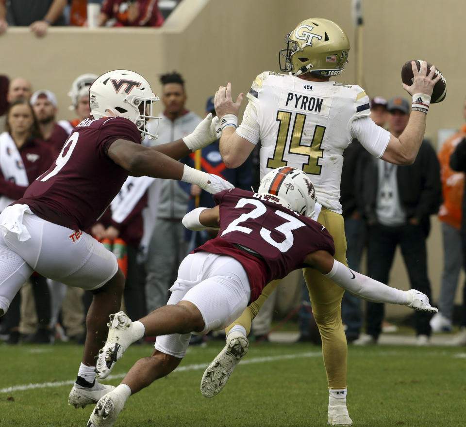 Georgia Tech quarterback Zach Pyron (14) is pressured by Virginia Tech defenders J.R. Walker (19) and Mansoor Delane (23) in the first half during an NCAA college football game, Saturday, Nov. 5 2022, in Blacksburg, Va. (Matt Gentry/The Roanoke Times via AP)