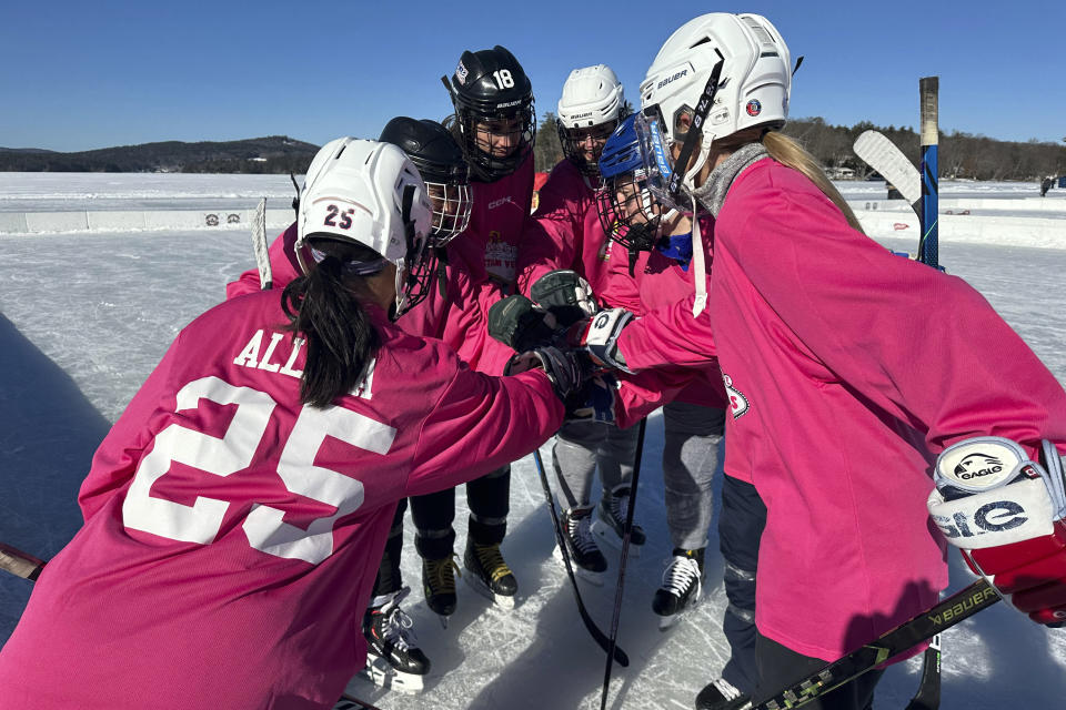 Hockey players huddle during the final of the women's open division at the Pond Hockey Classic in Meredith, N.H., on Sunday, Feb. 4, 2024.(AP Photo/Nick Perry)