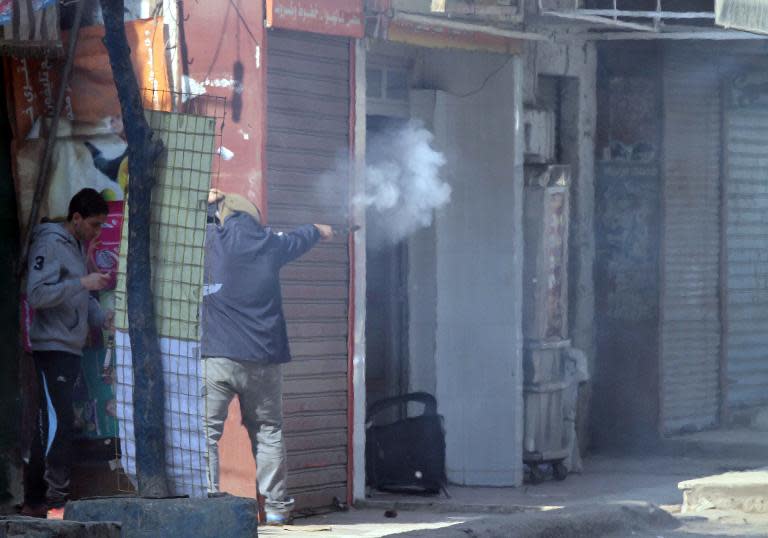 An Egyptian supporter of ousted president Mohamed Morsi shoots fireworks towards police during clashes in Cairo's working class district of Matariya on November 28, 2014