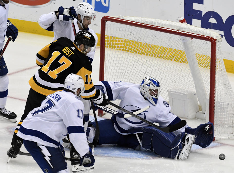 Pittsburgh Penguins right wing Bryan Rust (17) pressures Tampa Bay Lightning goalie Brian Elliott (1) during the first period of an NHL hockey game, Sunday, Feb. 26, 2023, in Pittsburgh. (AP Photo/Philip G. Pavely)