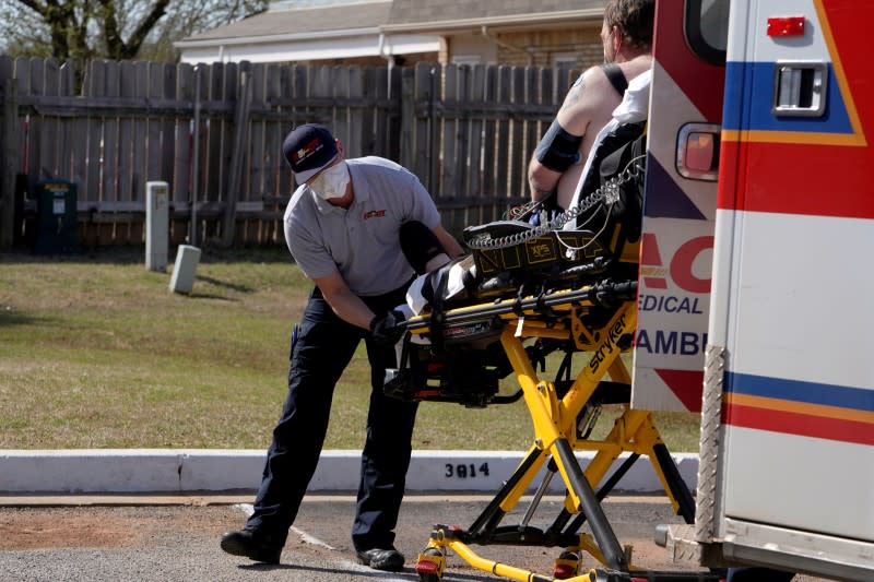 Paramedic Brian Myers loads up a potential coronavirus disease patient for transport in Shawnee