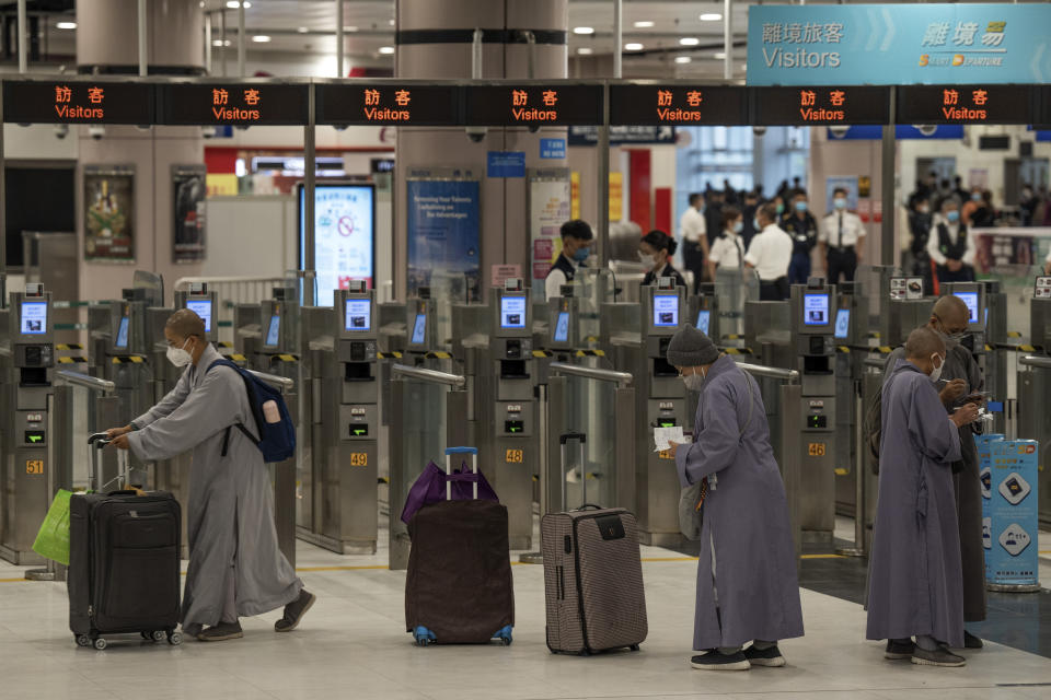 Nuns wearing face masks with their luggage arrive at the immigration counters of the departure hall at Lok Ma Chau station following the reopening of crossing border with mainland China, in Hong Kong, Sunday, Jan. 8, 2023. Travelers crossing between Hong Kong and mainland China, however, are still required to show a negative COVID-19 test taken within the last 48 hours, a measure China has protested when imposed by other countries. (AP Photo/Bertha Wang)