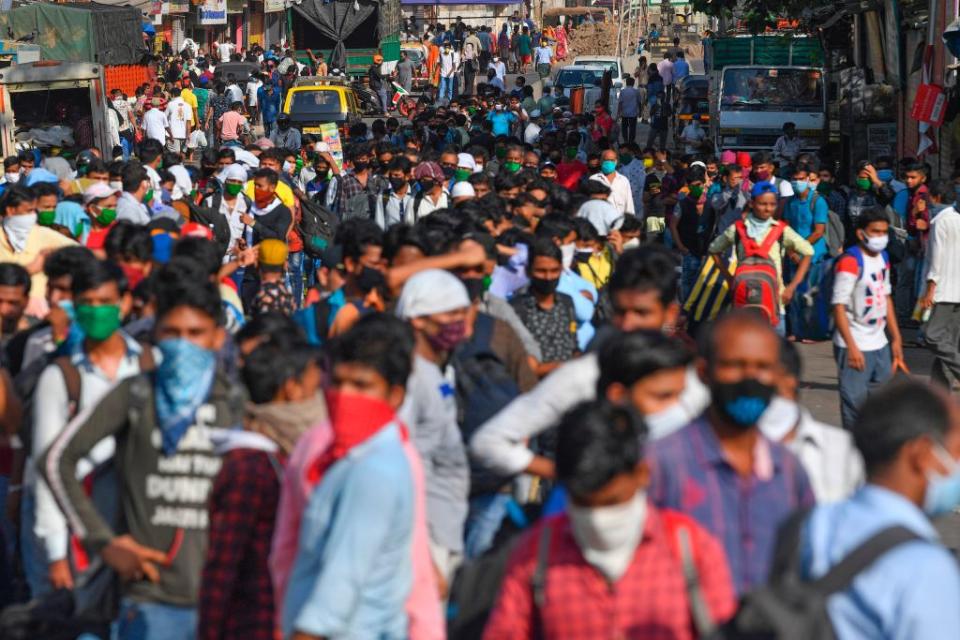 Migrant workers gather outside Dharavi slums to board a bus in Mumbai on May 12. Source: Getty