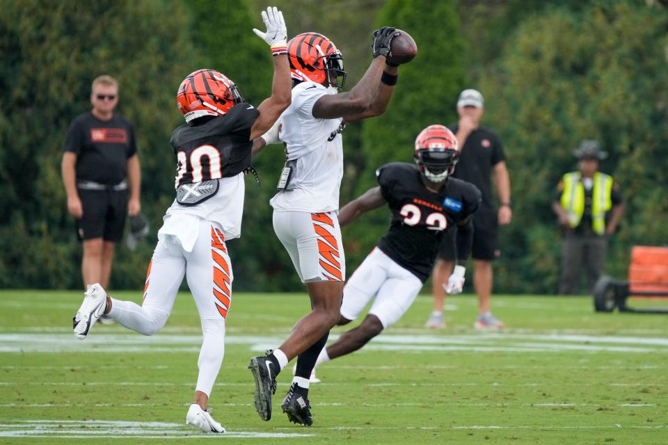 Cincinnati Bengals wide receiver Tee Higgins (5) catches a pass ahead of cornerback DJ Turner II (20) during a preseason training camp practice at the Paycor Stadium training facility in downtown Cincinnati on Wednesday, Aug. 16, 2023.