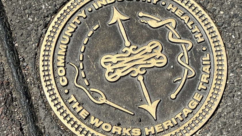 A bronze medallion fixed to the pavement marking a heritage trail