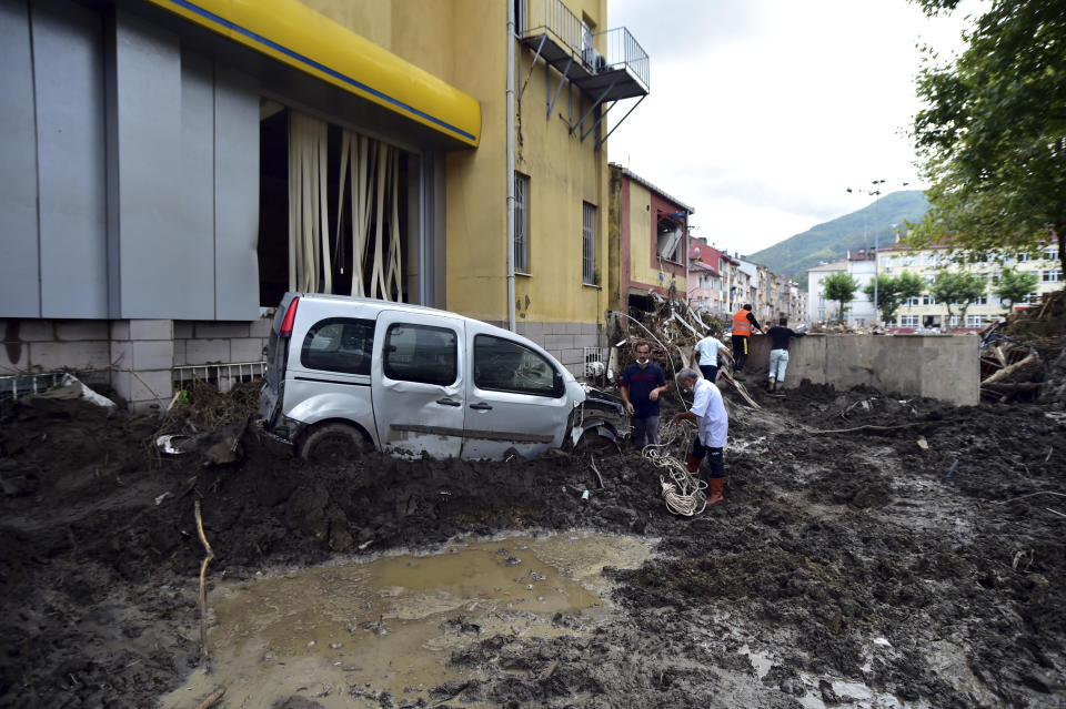 People watch the destruction after floods and mudslides killed about three dozens of people, in Bozkurt town of Kastamonu province, Turkey, Friday, Aug. 13, 2021. The death toll from devastating floods and mudslides in northern Turkey rose to at least 31 on Friday, officials said, as emergency services searched for survivors in collapsed buildings or swamped homes, shops and basements. An opposition politician said more than 300 people may be unaccounted-for.(AP Photo)