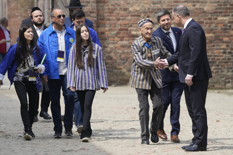 CAPTION CORRECTS THE NAME - Poland's President Andrzej Duda, right, and Auschwitz Survivor from U.S. Edward Mosberg, shake hands during the March of the Living annual observance that was not held for two years due to the global COVID-19 pandemic, in Oswiecim, Poland, Thursday, April 28, 2022. Only eight survivors and some 2,500 young Jews and non-Jews are taking part in the annual march that is scaled down this year because of the war in neighboring Ukraine that is fighting Russia's invasion. (AP Photo/Czarek Sokolowski)