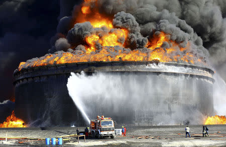 Firefighters work to put out the fire of a storage oil tank at the port of Es Sider in Ras Lanuf December 29, 2014. REUTERS/Stringer