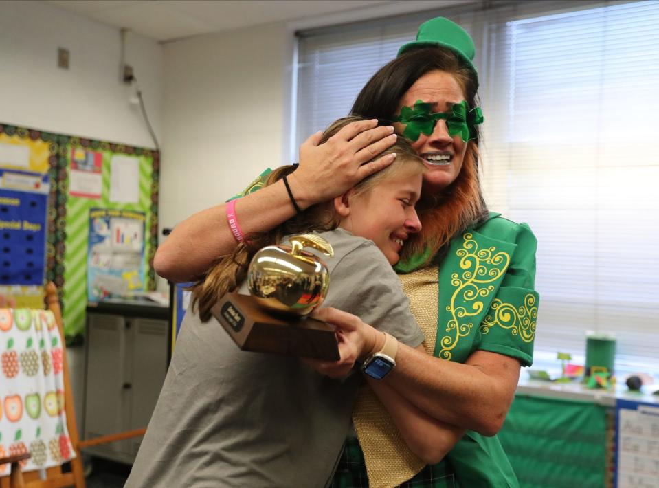 Pine Island Elementary School teacher Christine Bartz hugs her daughter Ava after receiving a Golden Apple award Thursday morning. Members of the Foundation for Lee County Public Schools surprised six teachers with the prestigious Golden Apple Award on Thursday, March 14, 2024. The Golden Apple Teacher Recognition Program was created by the foundation to help enhance and enrich public education by recognizing and rewarding excellence in teaching. The winners included: Christine Bartz of Pine Island Elementary School; Sara Kizzire of Lehigh Senior High; Jill Klausing of Dunbar High School; Jessica Lisi of Tanglewood Elementary; Michelle Smith of Lehigh Senior High; and Sarah Thornburg of Cypress Lake High School.