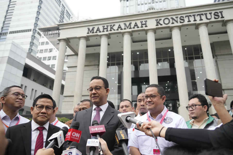 Losing presidential candidate Anies Baswedan, center left, talks to journalist as his running mate Muhaimin Iskandar, second left, listens upon their arrival for hearing appeals against the presidential election results, which were lodged by losing candidates, at the Constitutional Court in Jakarta, Indonesia, Wednesday, March 27, 2024. (AP Photo/Achmad Ibrahim)