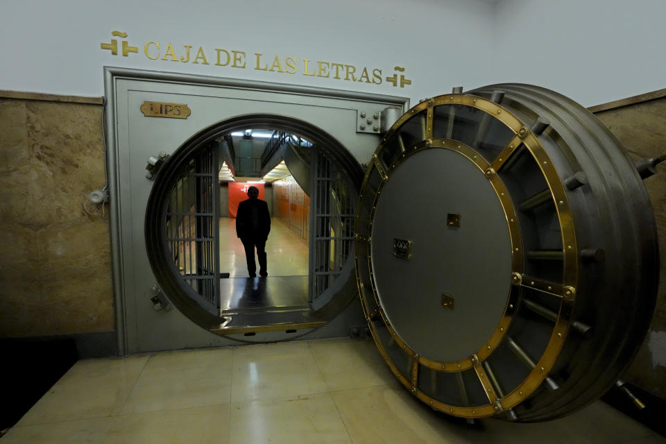 El director del Instituto Cervantes, Luis García Montero, posa junto a la puerta de una antigua cámara acorazada antes de una entrevista con The Associated Press en la sede de la institución en Madrid, el 24 de abril de 2024. (AP Foto/Paul White)