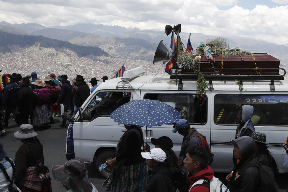Anti-government demonstrators accompany a coffin that contains the remains of a person killed in clashes between supporters of former President Evo Morales and security forces, in a funeral procession into La Paz, Bolivia, Thursday, Nov. 21, 2019. At least eight people were killed Tuesday when security forces cleared a blockade of a fuel plant by supporters of former President Evo Morales at protesters in the city of El Alto. (AP Photo/Natacha Pisarenko)
