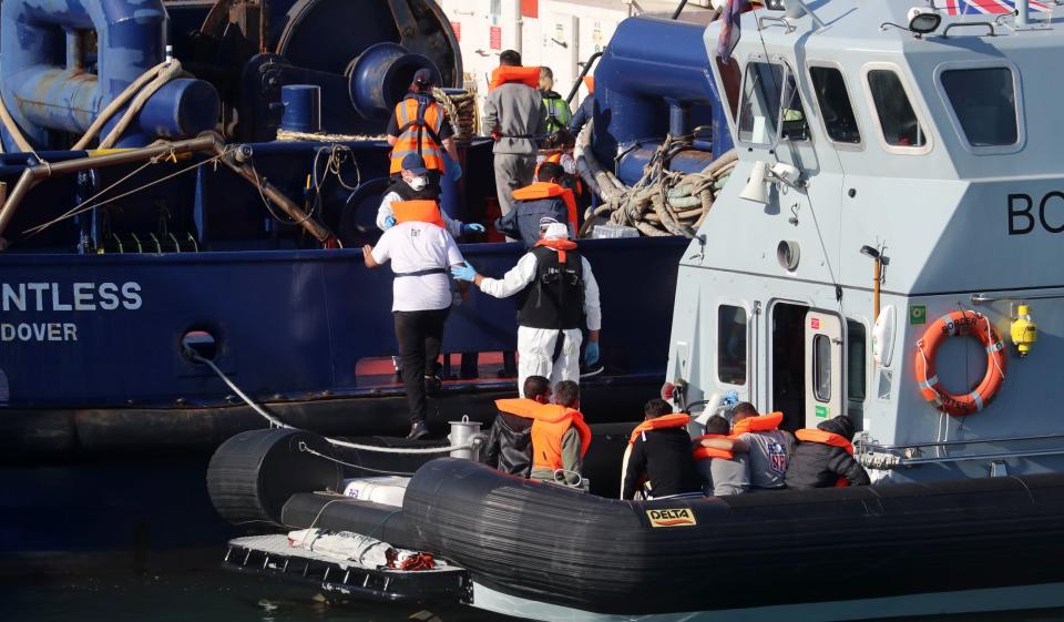 Border Force escorts people off a boat at Dover (PA)