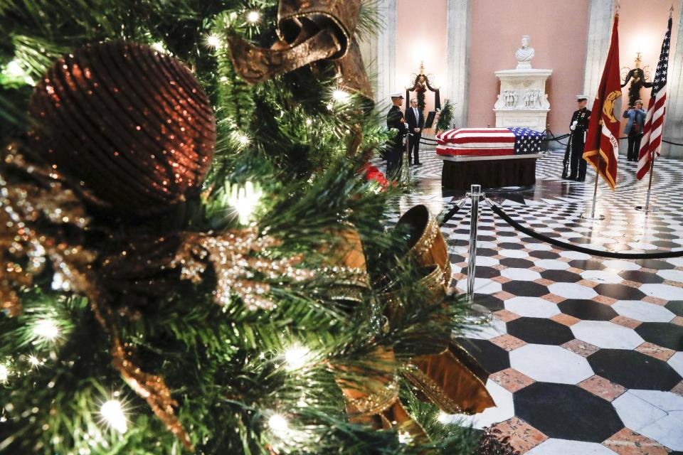 A Christmas tree is displayed in the State House rotunda as Marines stand guard at the casket of John Glenn, Friday, Dec. 16, 2016, in Columbus, Ohio. Glenn's home state and the nation began saying goodbye to the famed astronaut who died last week at the age of 95. (AP Photo/John Minchillo)