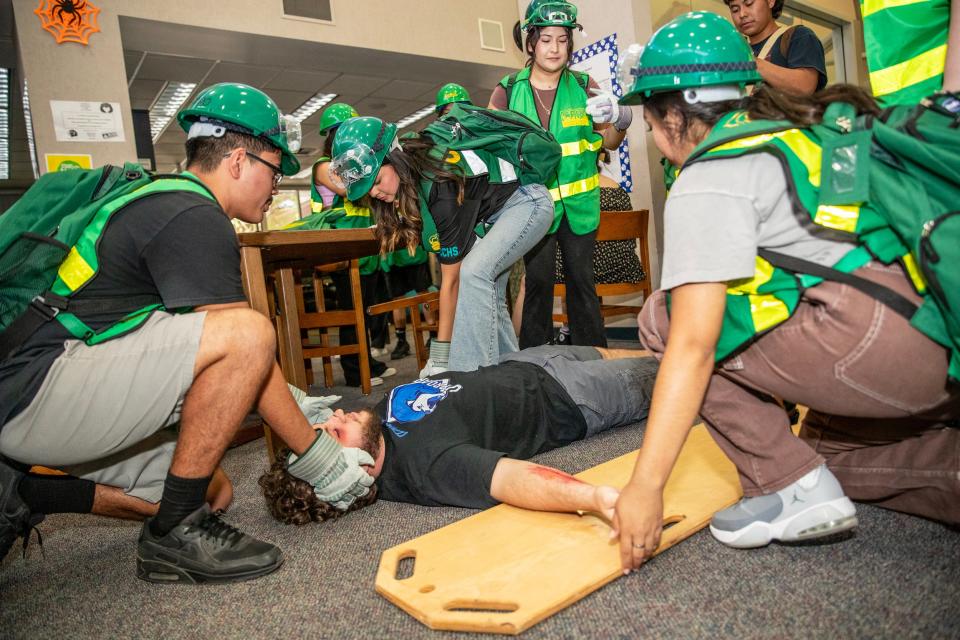 Health and Environmental Academy of Learning students at Cathedral City High School prepare to lift Codey Rasmussen during the Great Shakeout Drill at the school in Cathedral City, Calif., on Thursday, October 18, 2023.