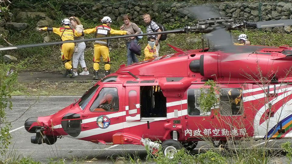 People leave a helicopter after being rescued from an isolated area following a powerful earthquake in Hualien City, Taiwan, Saturday, April 6, 2024 - Suo Takekuma/Kyodo News/AP