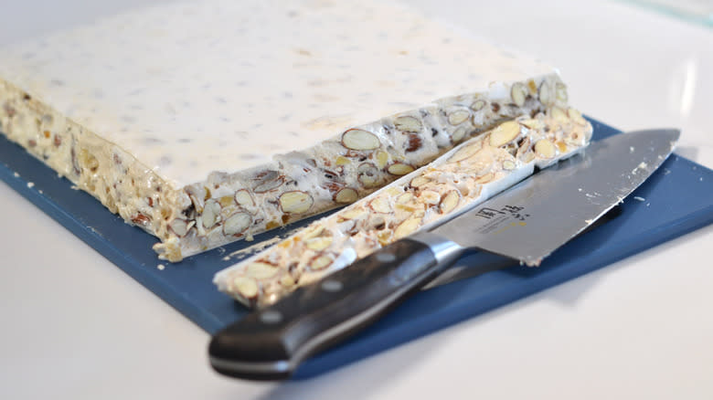 sliced nougat with knife on cutting board