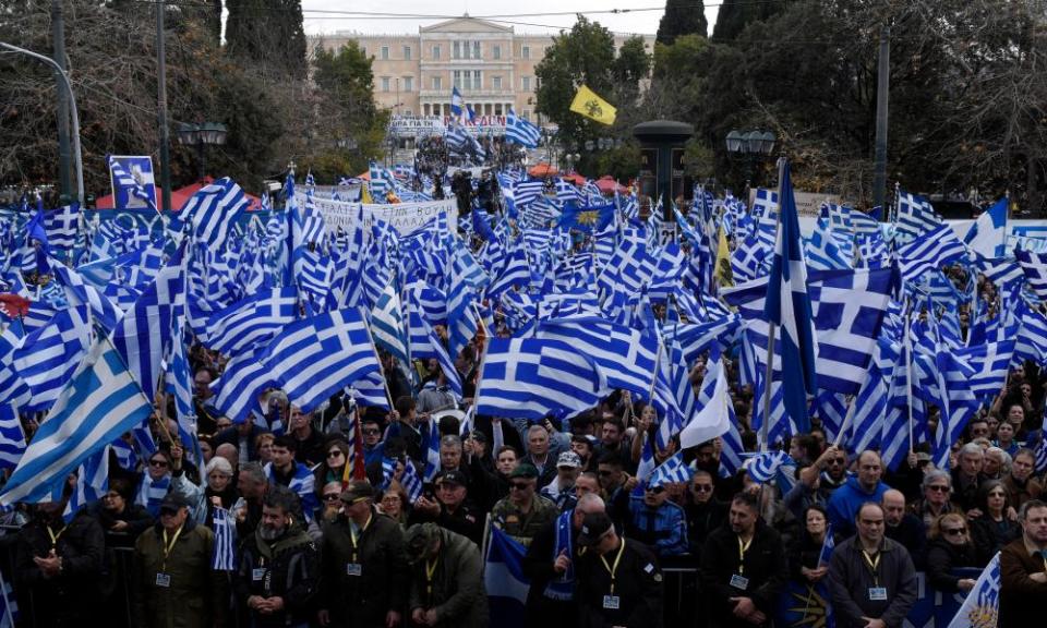 Demonstrators hold Greek flags during a rally outside parliament in Athens.