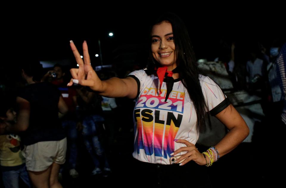 A supporter of Nicaragua's President Daniel Ortega and vice presidential candidate, his wife, Rosario Murillo, poses while celebrating after preliminary results showed Ortega is expected to be re-elected, at Victoria Square in Managua on Nov. 7, 2021.