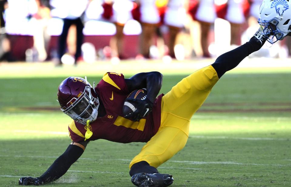 USC receiver Zachariah Branch holds onto the ball while crashing to the turf.