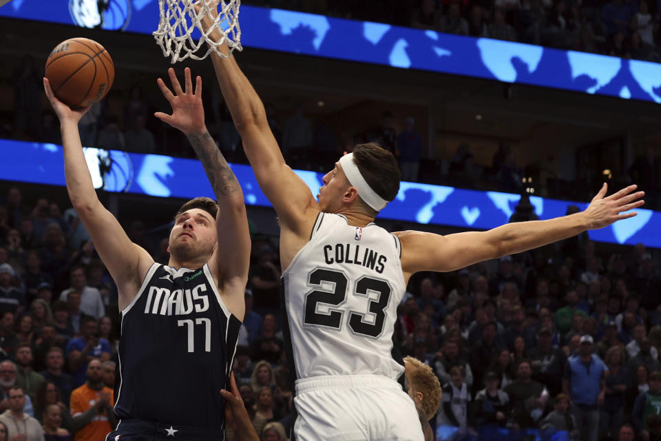 Dallas Mavericks guard Luka Doncic (77) shoots against San Antonio Spurs forward Zach Collins (23) in the first half of an NBA basketball game Saturday, Dec. 23, 2023, in Dallas. (AP Photo/Richard W. Rodriguez)