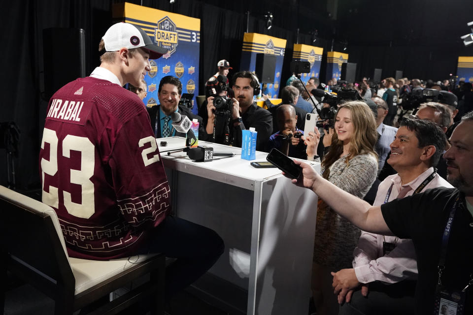 Michael Hrabal, left, speaks to reporters after being picked by the Arizona Coyotes during the second round of the NHL hockey draft Thursday, June 29, 2023, in Nashville, Tenn. (AP Photo/George Walker IV)