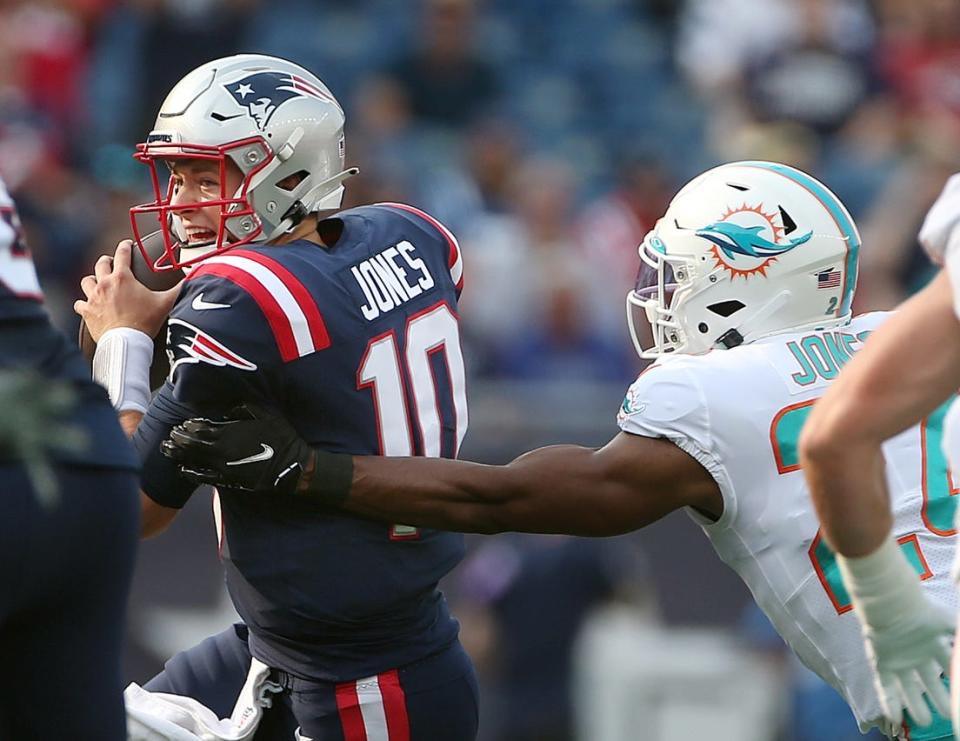 Patriots QB #10 Mac Jones is sacked in the 1st quarter by Miami corner #24 Byron Jones.[The Providence Journal/Bob Breidenbach]