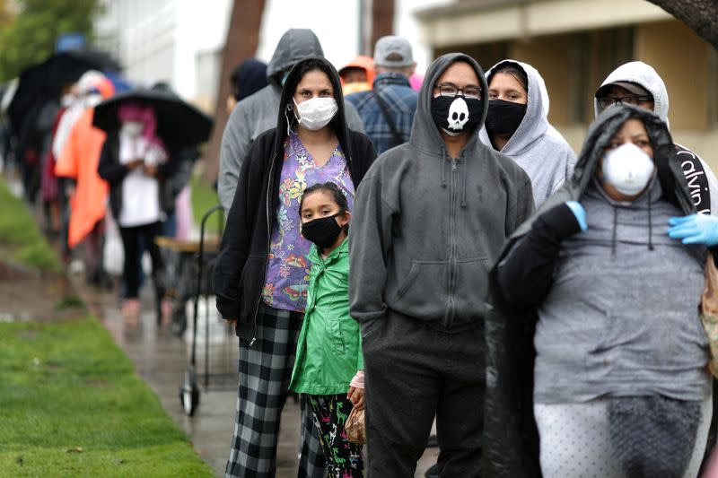 FILE PHOTO: People queue to pick up fresh food at a Los Angeles Regional Food Bank giveaway of 2,000 boxes of groceries, as the spread of the coronavirus disease (COVID-19) continues, in Los Angeles