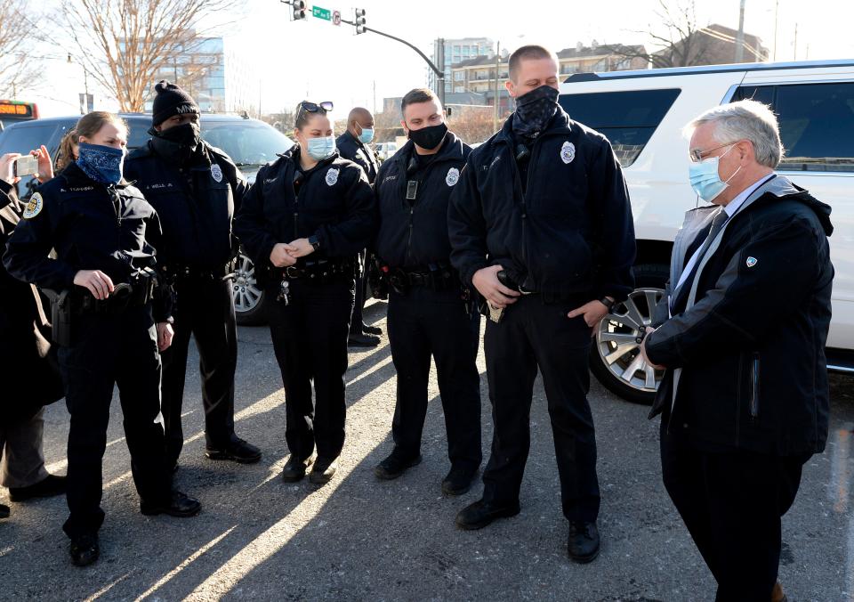 Nashville Mayor John Cooper talks with Nashville Metro police officers Amanda Topping, left, James Wells, Brenna Hosey, Michael Sipos and James Luellen, before sharing their experiences saving lives before the explosion on Christmas Day during a press conference on Sunday, December 27, 2020 in Nashville, Tenn. 