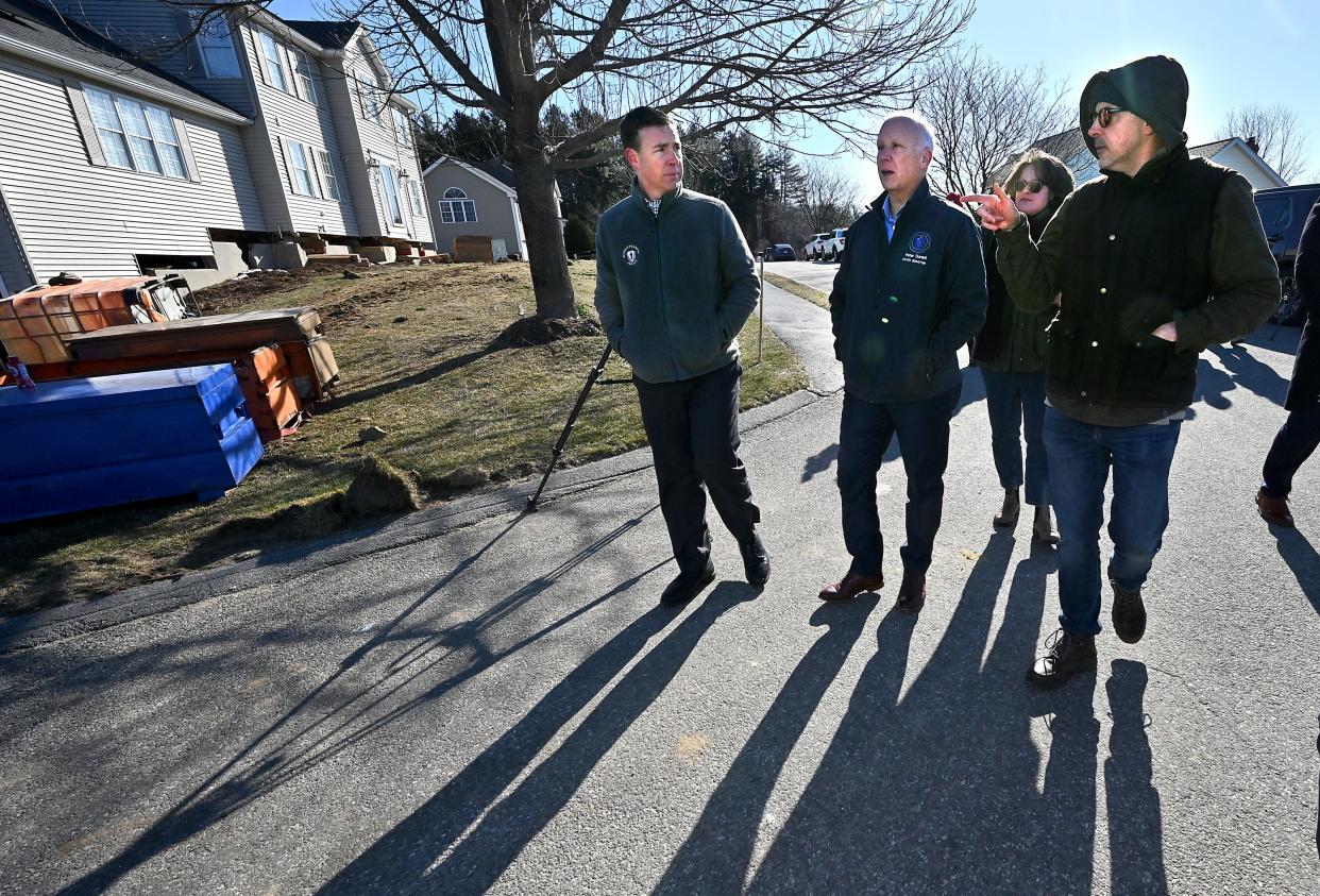 William Circle homeowner Jeffrey Haynes, right, walks around his home with state Sens. Ryan Fattman, left, and Peter Durant and state Rep. Meghan Kilcoyne as it is raised above its foundation due to the content of pyrrhotite, a mineral that causes foundation crumbling.