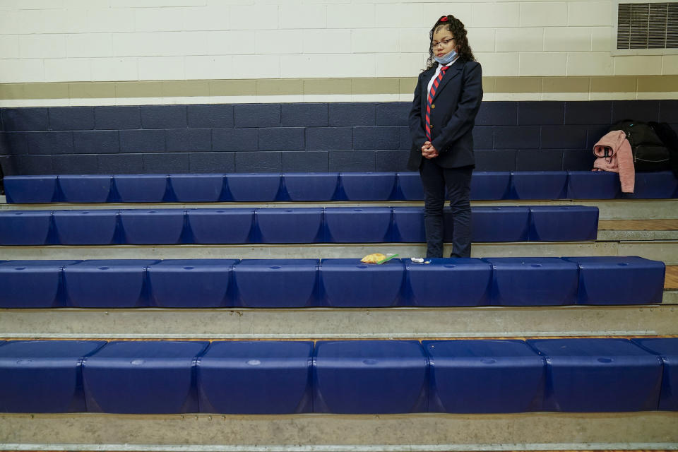 Annii Kinepoway pauses during a prayer in the bleachers at St. Marcus Lutheran School during the school's morning prayer Wednesday, Oct. 19, 2022, in Milwaukee. Annii’s mother could only afford this educational opportunity because of school choice programs. (AP Photo/Morry Gash)