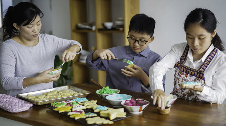 Family decorating baked sugar cookies