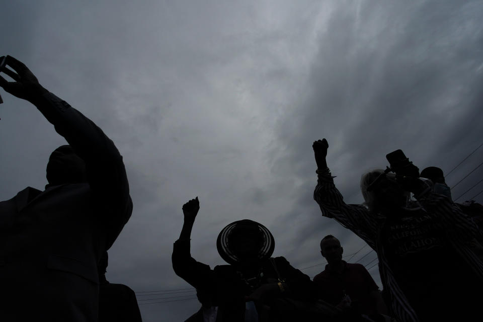 FILE - People raise up their arms during the dedication of a prayer wall outside of the historic Vernon African Methodist Episcopal Church in the Greenwood neighborhood during the centennial of the Tulsa Race Massacre, May 31, 2021, in Tulsa, Okla. An Oklahoma judge has thrown out a lawsuit seeking reparations for the 1921 Tulsa Race Massacre, dashing an effort to obtain some measure of legal justice by survivors of the deadly racist rampage. (AP Photo/John Locher, file)