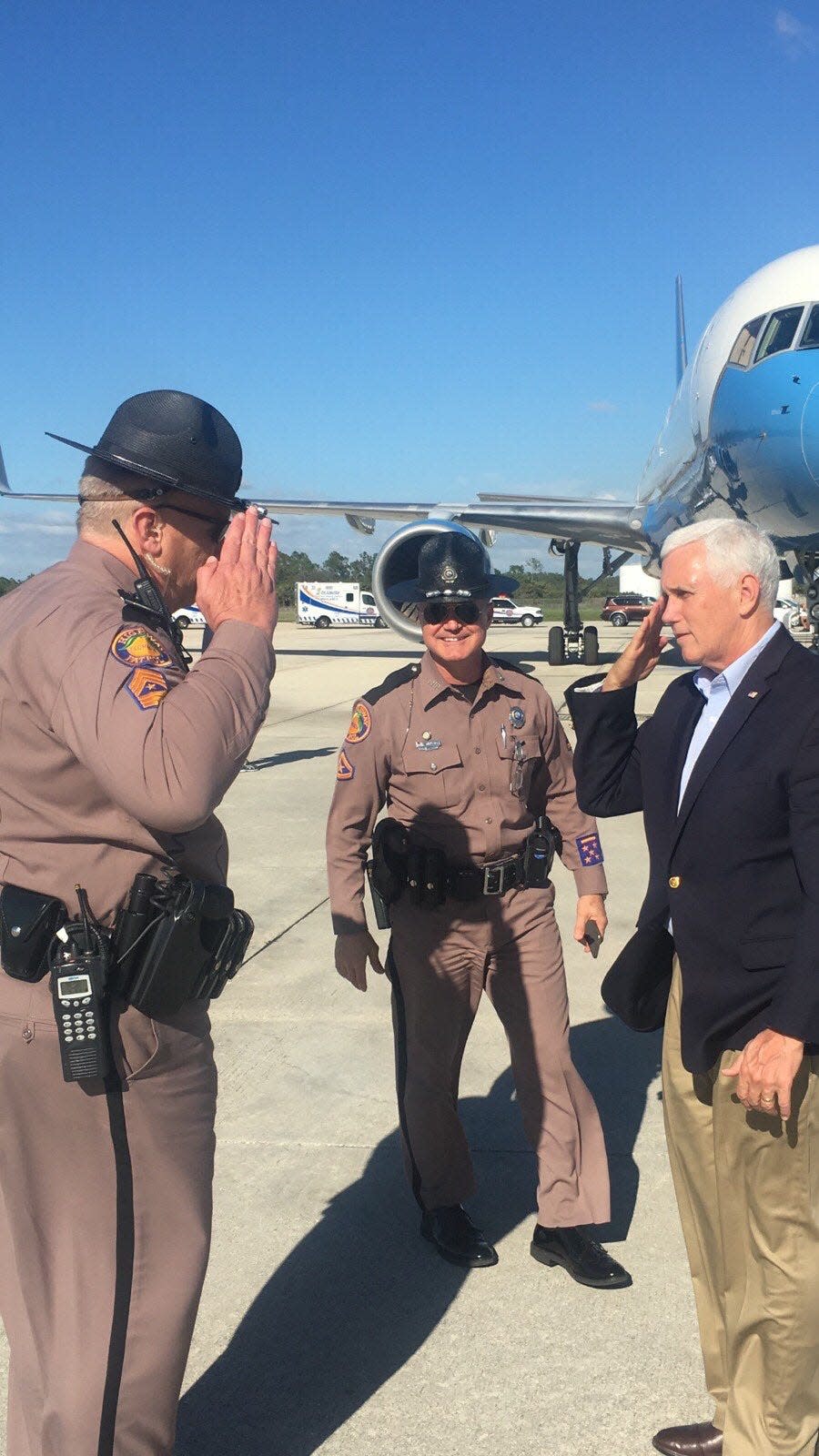 A Florida Highway Patrol trooper from FHP's Fort Myers' headquarters offers then-Vice President Mike Pence a salute as he prepares to leave Southwest Florida International Airport after a 2019 weekend visit on Sanibel Island.