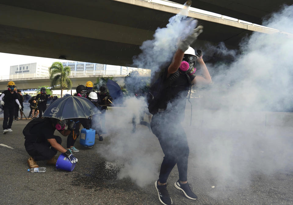 A demonstrator throws back a tear gas canister during a protest in Hong Kong, Saturday, Aug. 24, 2019. Chinese police said Saturday they released an employee at the British Consulate in Hong Kong as the city's pro-democracy protesters took to the streets again, this time to call for the removal of "smart lampposts" that raised fears of stepped-up surveillance. (AP Photo/Vincent Yu)