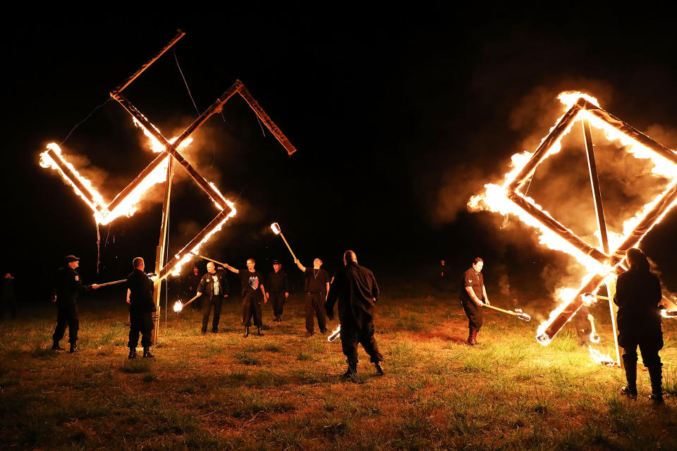 Members of the National Socialist Movement, one of the largest neo-Nazi groups in the US, hold a swastika burning after a rally on April 21, 2018 in Draketown, Georgia. Community members had opposed the rally in Newnan and came out to embrace racial unity in the small Georgia town. Fearing a repeat of the violence that broke out after Charlottesville, hundreds of police officers were stationed in the town during the rally in an attempt to keep the anti racist protesters and neo-Nazi groups separated