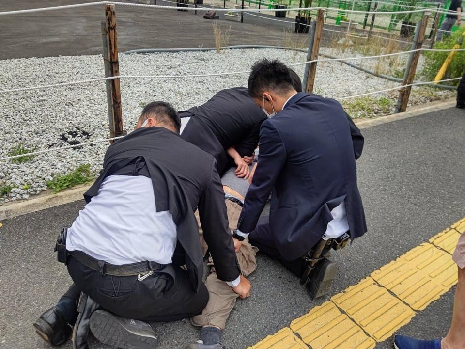日本前首相安倍晉三今天上午遭槍擊，經搶救後不治身亡，享壽67歲。圖為兇手被制服情形。/取自twitter