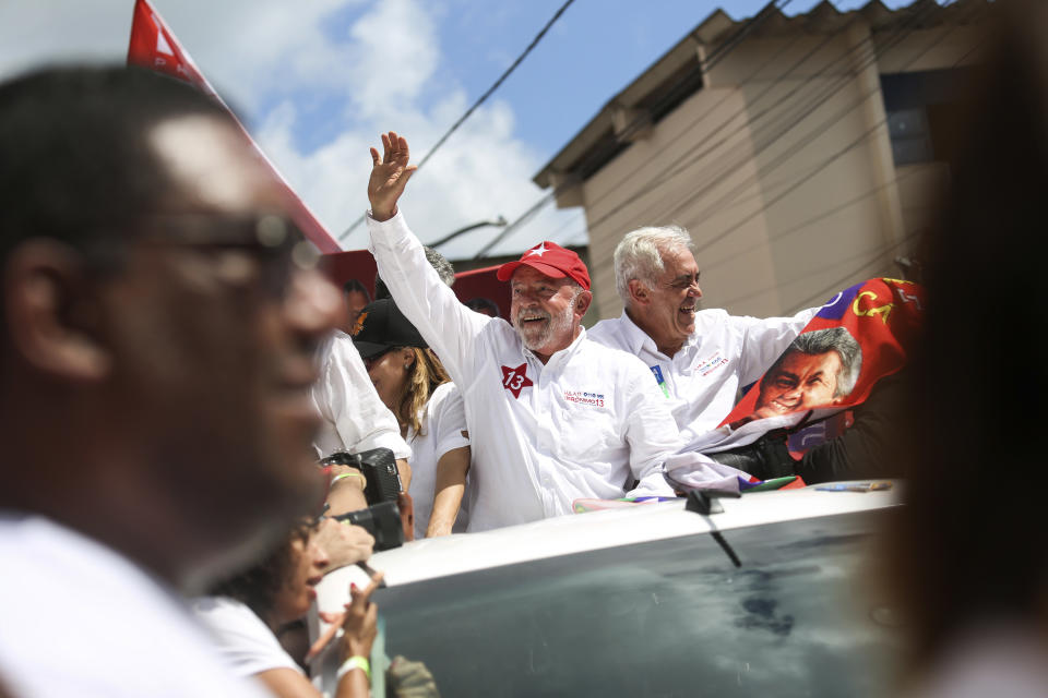 FILE - Brazil's former President Luiz Inacio Lula da Silva, center, who is running for president again with the Workers' Party campaign waves in Salvador, Brazil, Sept. 30, 2022. Despite the smoke clogging the air of entire Amazon cities, state elections have largely ignored environmental issues. Far-right President Jair Bolsonaro is seeking a second four-year term against leftist da Silva, who ruled Brazil between 2003 and 2010. (AP Photo/Raphael Muller, File)