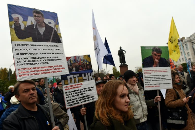 Demonstrators hold banners bearing portraits of assassinated Russian opposition leader Boris Nemtsov, during an antiwar rally in central Moscow