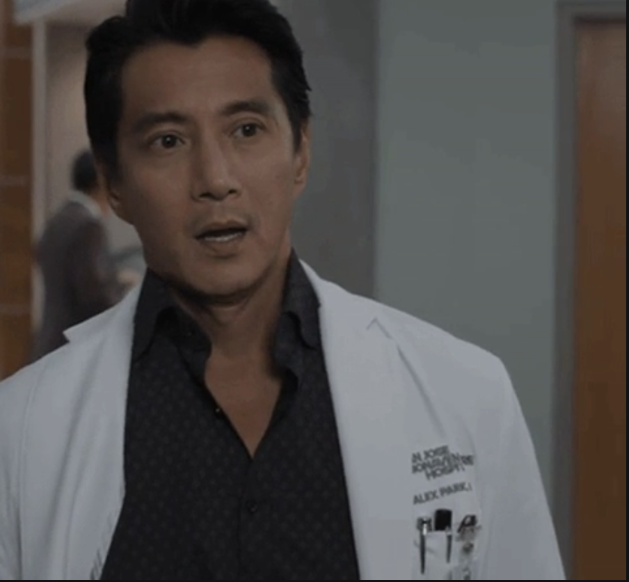 Alex Park in white lab coat, patterned shirt, in a hospital scene from 
